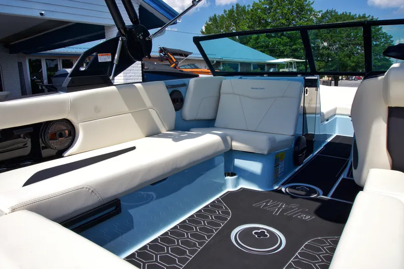 Slide: The Image of 2024 MasterCraft NXT23 boat interior with white seating and modern design. - 15