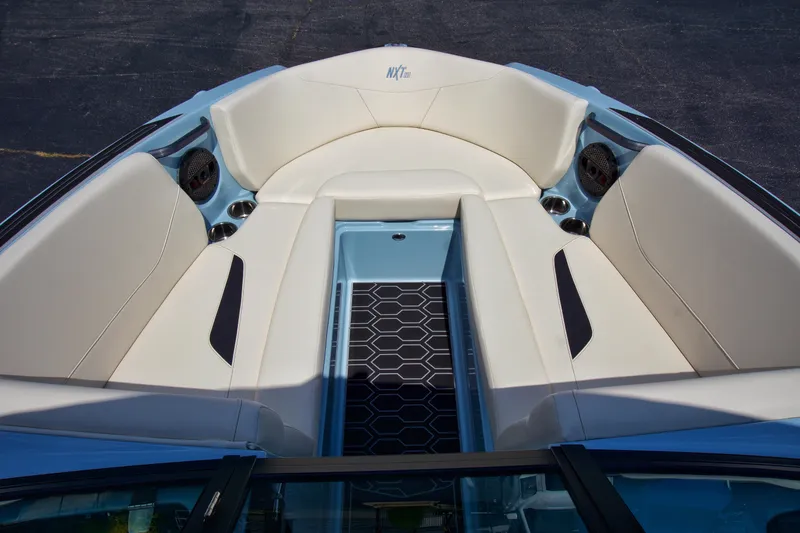 Slide: The Image of 2024 MasterCraft NXT23 boat interior with beige seating and black accents. - 17