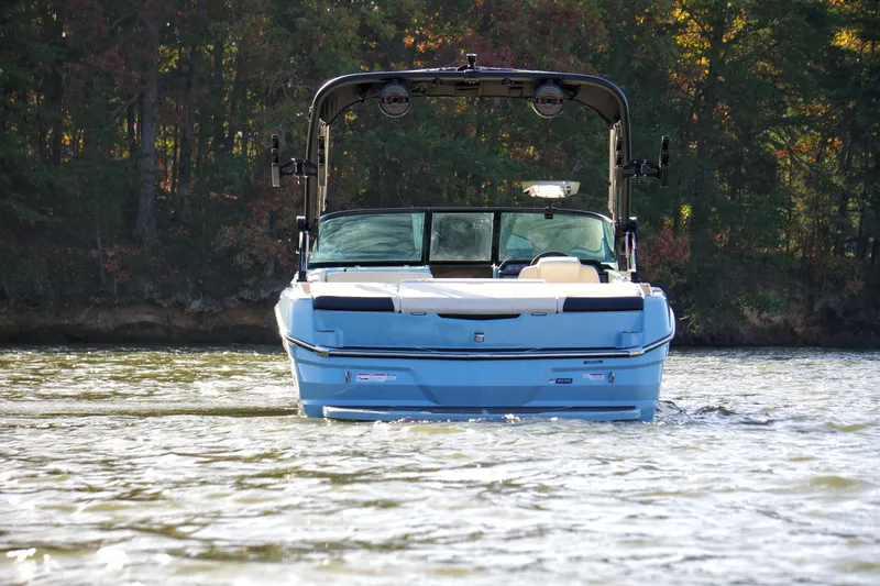 Slide: The Image of 2024 MasterCraft NXT23 boat on a lake, surrounded by trees. - 5