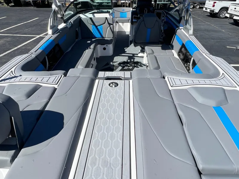 Slide: The Image of 2024 MasterCraft XT24 boat interior with gray and blue seating, spacious layout. - 10