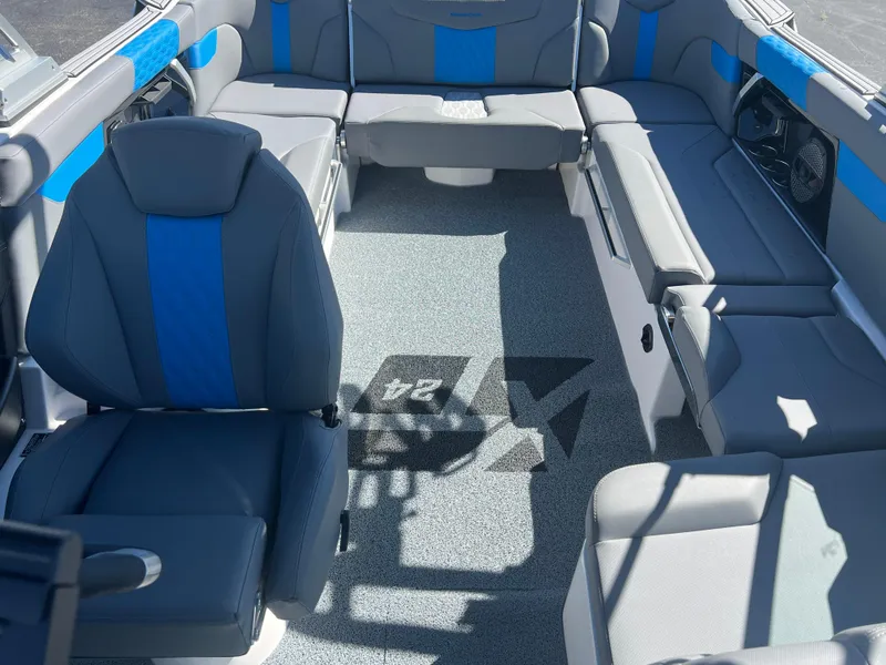 Slide: The Image of 2024 MasterCraft XT24 boat interior with blue and gray seating, spacious layout. - 13