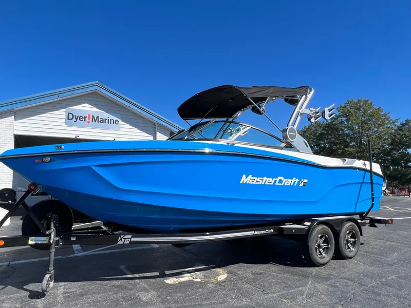 Slide: The Image of 2024 MasterCraft XT24 boat in vibrant blue on trailer at Dyer Marine. - 5