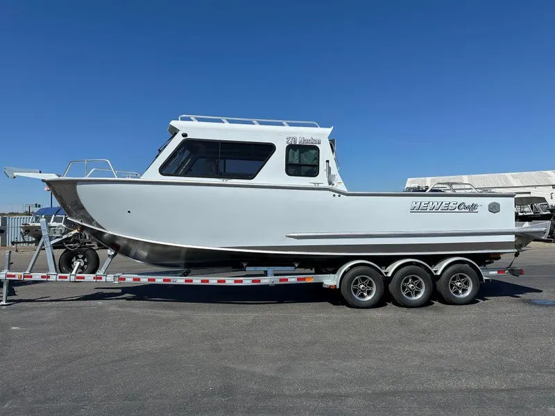 Slide: The Image of 2024 Hewescraft 270 Alaskan boat on a trailer under clear blue sky. - 2