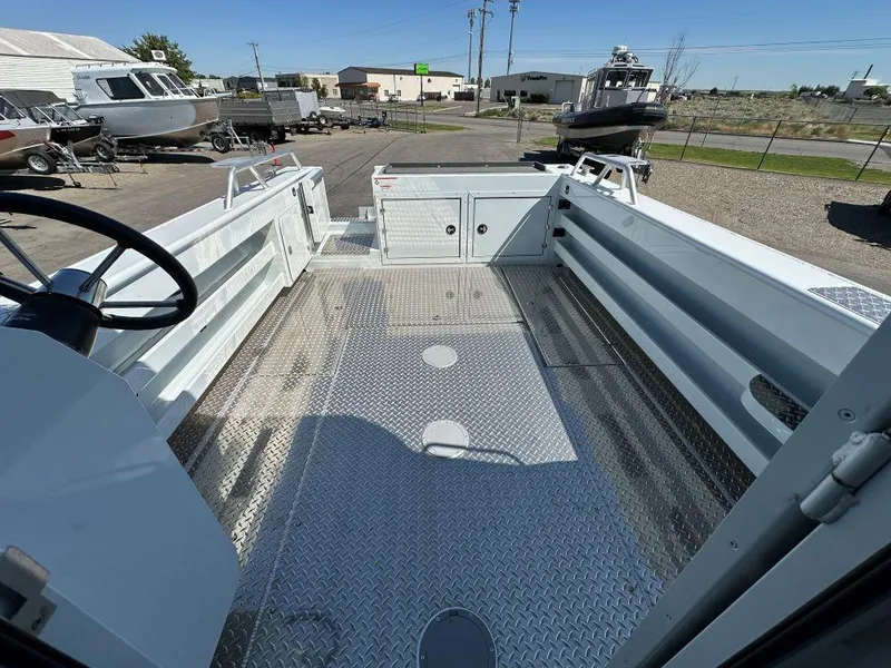 Slide: The Image of 2024 Hewescraft 270 Alaskan boat interior with aluminum flooring and open deck view. - 7