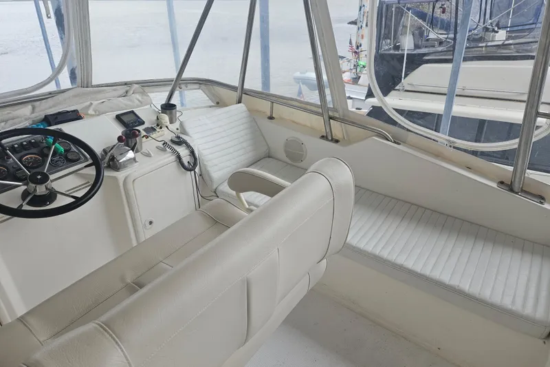 Slide: The Image of Interior of 1999 Riviera 40AC boat with white seating and steering controls. - 10