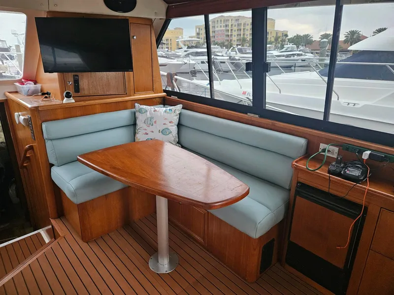 Slide: The Image of Interior of 1999 Riviera 40AC yacht with dining area and marina view. - 15