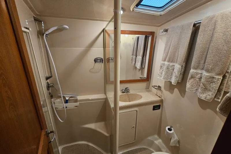 Slide: The Image of 1999 Riviera 40AC yacht bathroom with shower, sink, and towels. - 18