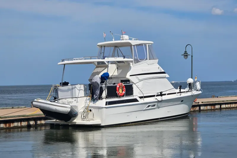 Slide: The Image of 1999 Riviera 40AC yacht docked at a marina under a clear blue sky. - 3
