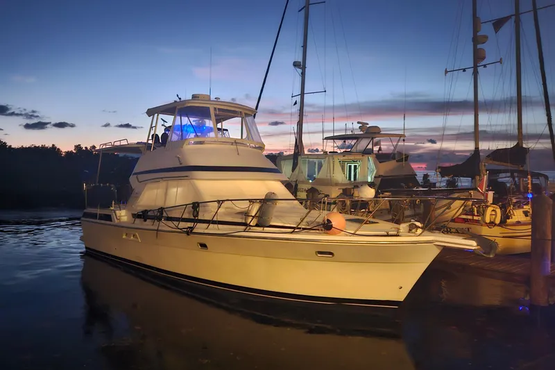 Slide: The Image of 1999 Riviera 40AC yacht docked at sunset, serene waterfront scene. - 5