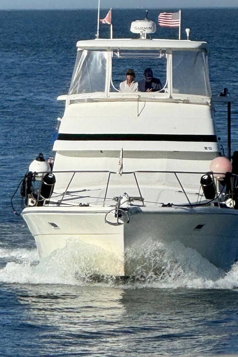 Slide: The Image of 1999 Riviera 40AC yacht cruising on open water with two people onboard. - 7