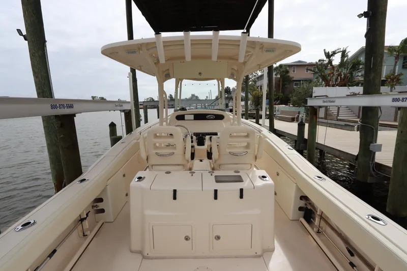 Slide: The Image of 2015 Grady-White Canyon 306 boat interior at dock, showcasing seating and helm. - 11