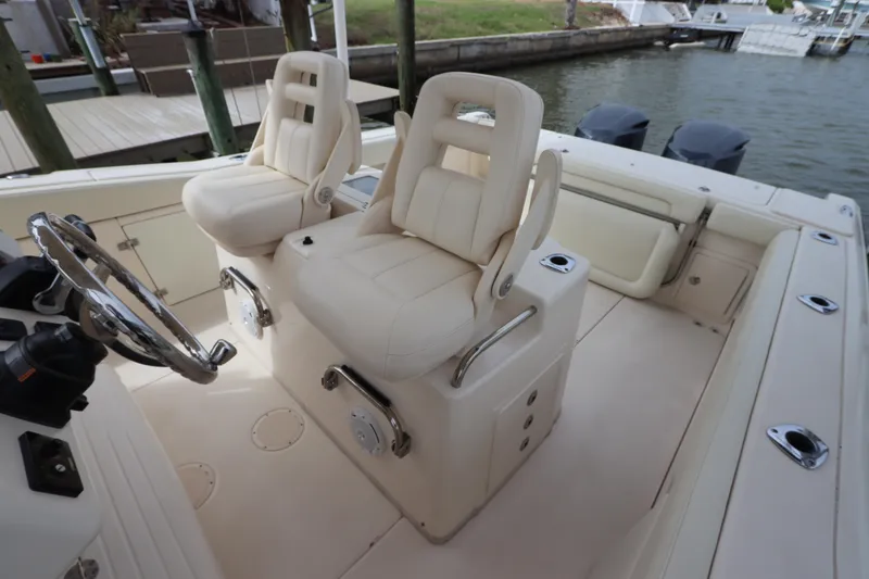 Slide: The Image of 2015 Grady-White Canyon 306 boat interior with dual captain's chairs and steering wheel. - 16