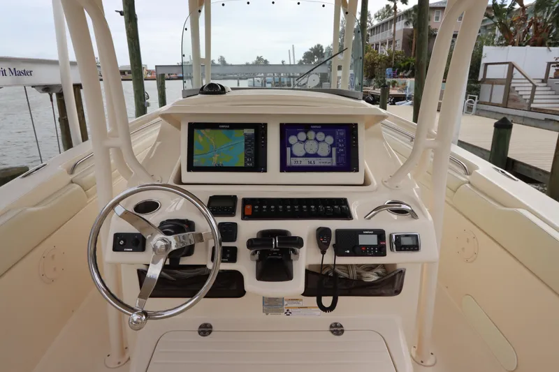Slide: The Image of 2015 Grady-White Canyon 306 boat dashboard with navigation screens and steering wheel. - 18