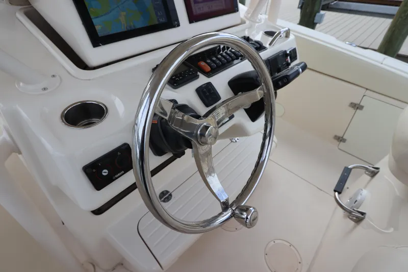 Slide: The Image of Steering wheel and controls of a 2015 Grady-White Canyon 306 boat. - 23