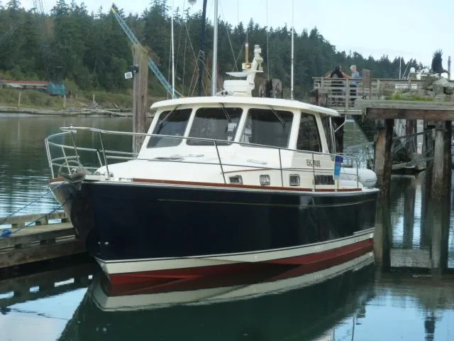 Slide: The Image of 2006 Sabre 38 Express boat docked in a serene marina setting. - 1