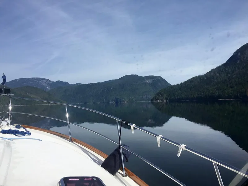 Slide: The Image of 2006 Sabre 38 Express cruising on a serene lake with mountainous backdrop. - 14