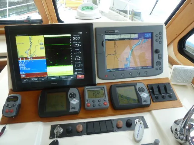 Slide: The Image of Navigation equipment on 2006 Sabre 38 Express boat dashboard, featuring multiple screens and controls. - 16