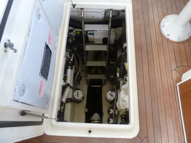 Slide: The Image of Engine compartment of a 2006 Sabre 38 Express boat, showing mechanical components and access ladder. - 26