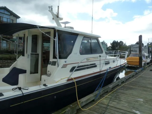 Slide: The Image of 2006 Sabre 38 Express yacht docked at a marina under cloudy skies. - 4