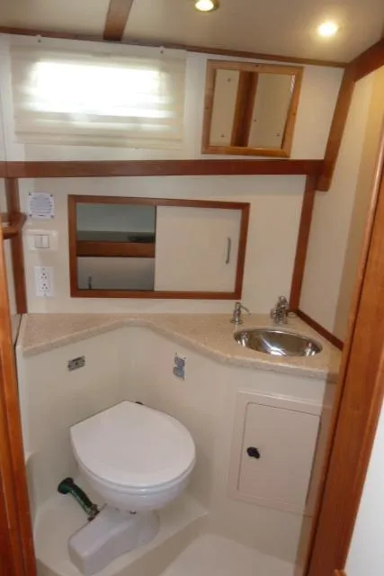 Slide: The Image of 2006 Sabre 38 Express yacht bathroom with toilet, sink, and storage cabinets. - 45