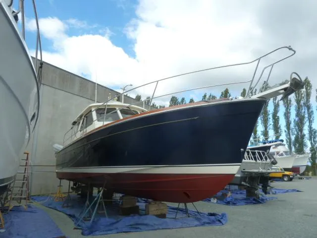 Slide: The Image of 2006 Sabre 38 Express boat on dry dock, blue hull, under cloudy sky. - 47
