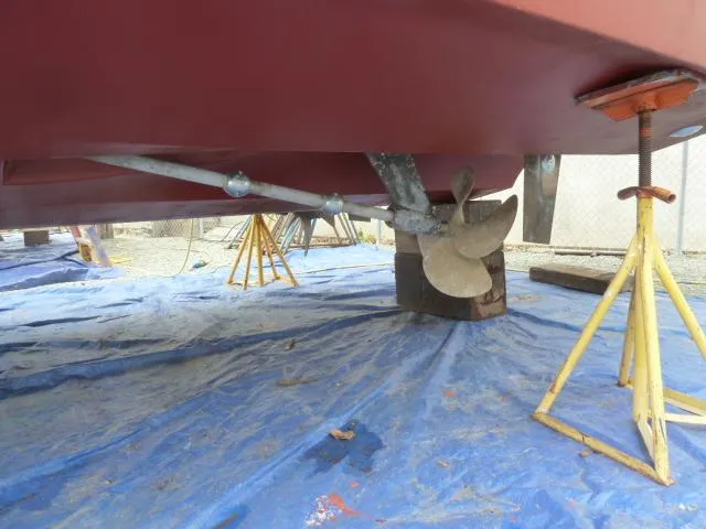 Slide: The Image of 2006 Sabre 38 Express boat underside with propeller and supports on blue tarp. - 48