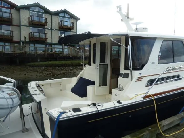 Slide: The Image of 2006 Sabre 38 Express yacht docked near waterfront buildings. - 5