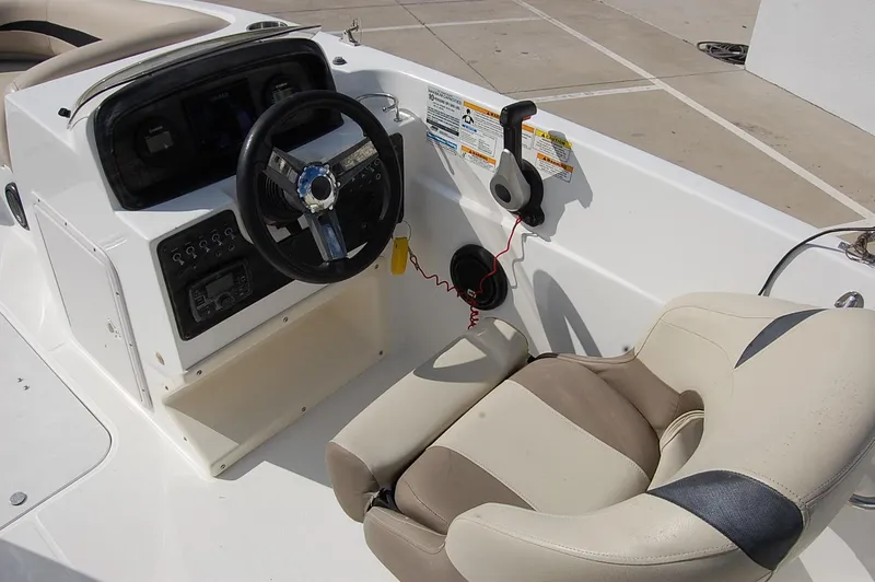 Slide: The Image of 2019 Hurricane SunDeck Sport 188 OB boat cockpit with steering wheel and beige seating. - 12