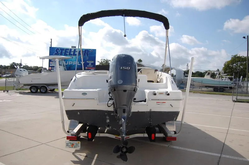 Slide: The Image of 2019 Hurricane SunDeck Sport 188 OB boat, rear view with outboard motor, parked outdoors. - 2