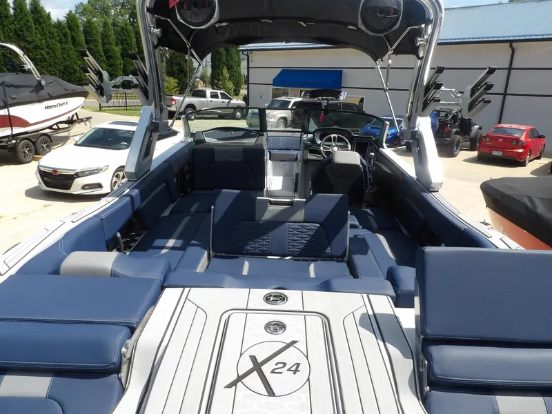 Slide: The Image of 2024 MasterCraft X24 boat interior with blue seating and sleek design. - 13