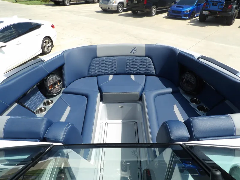 Slide: The Image of 2024 MasterCraft X24 boat interior with blue seating and cup holders. - 17