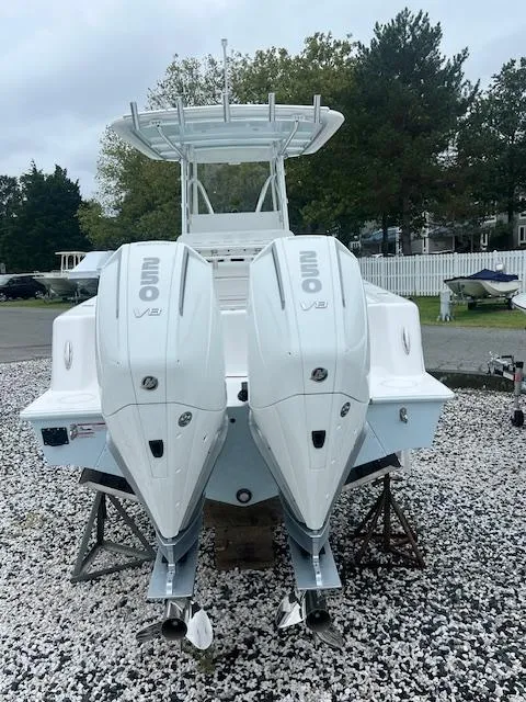 Slide: The Image of 2024 Contender 28 Tournament boat with dual outboard engines, parked on gravel. - 1