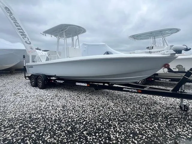 Slide: The Image of 2024 Contender 26 Bay boat on trailer, displayed outdoors under cloudy skies. - 0