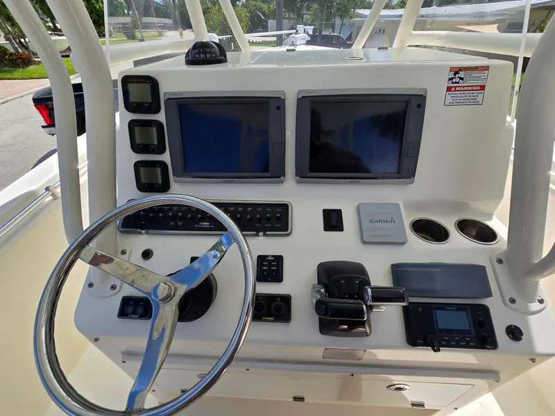 Slide: The Image of 2015 Cobia 296 Center Console dashboard with steering wheel and navigation screens. - 12