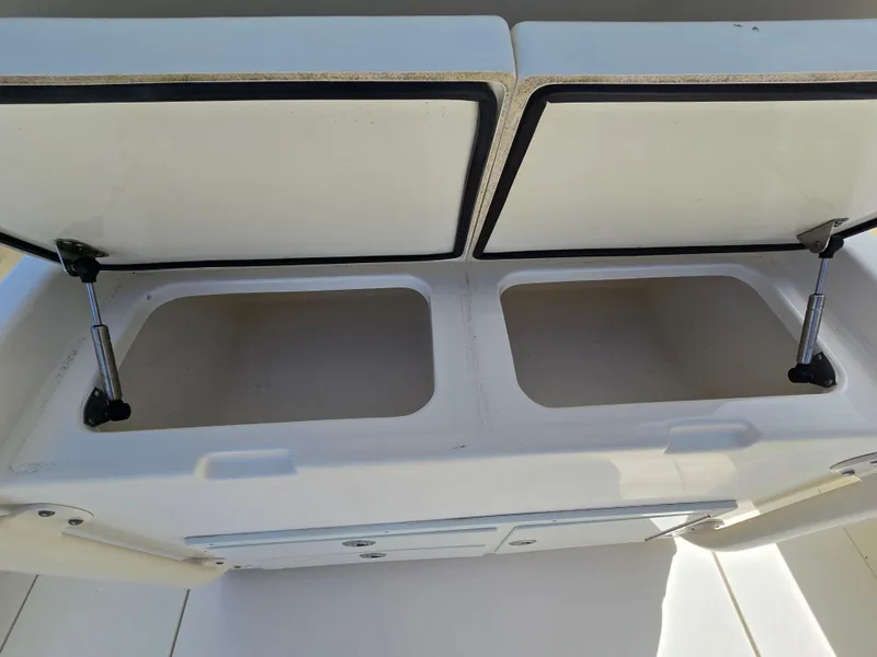 Slide: The Image of Open storage compartments on a 2015 Cobia 296 Center Console boat. - 18