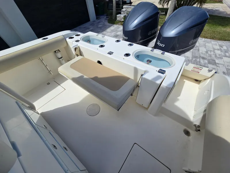 Slide: The Image of 2015 Cobia 296 Center Console boat with Yamaha engines, featuring spacious deck and seating. - 22