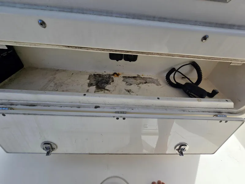 Slide: The Image of Open storage compartment on a 2015 Cobia 296 Center Console boat. - 23