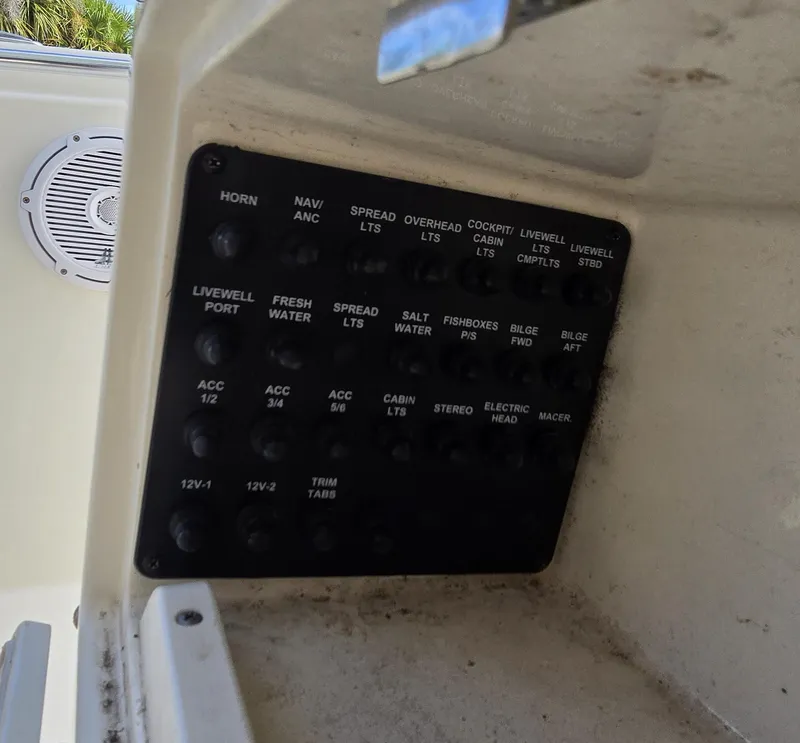 Slide: The Image of Control panel on a 2015 Cobia 296 Center Console boat, featuring various switches. - 24