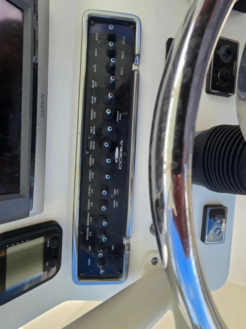 Slide: The Image of Control panel of 2015 Cobia 296 Center Console boat with steering wheel and Garmin display. - 25