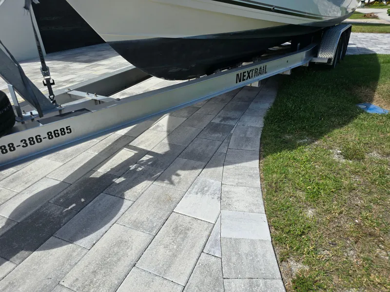 Slide: The Image of 2015 Cobia 296 Center Console boat on trailer, parked on paved driveway. - 3