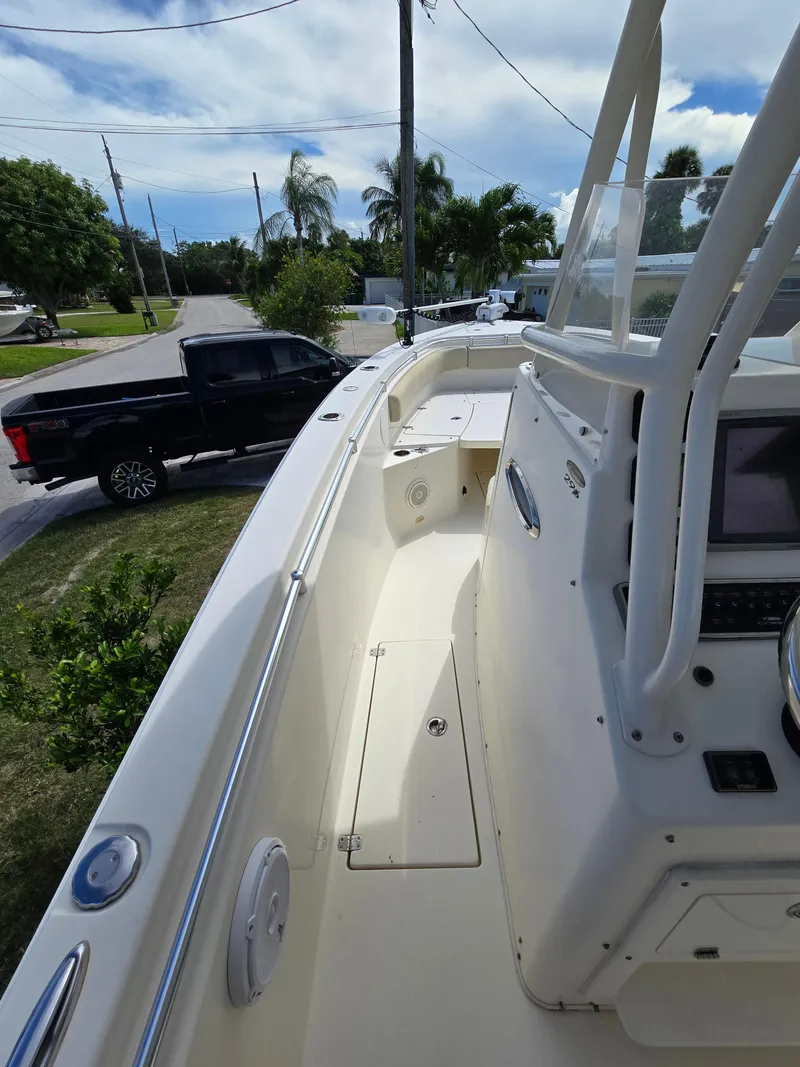 Slide: The Image of 2015 Cobia 296 Center Console boat, docked near a residential street with a black truck. - 31