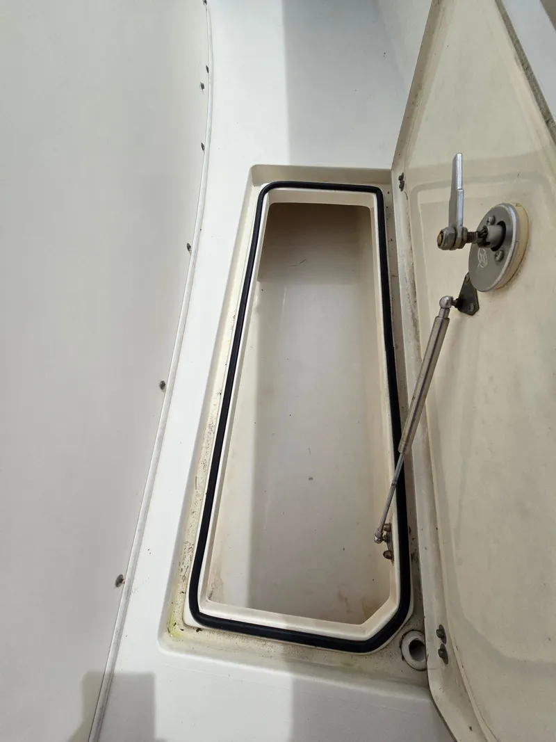 Slide: The Image of Open storage compartment on a 2015 Cobia 296 Center Console boat. - 33