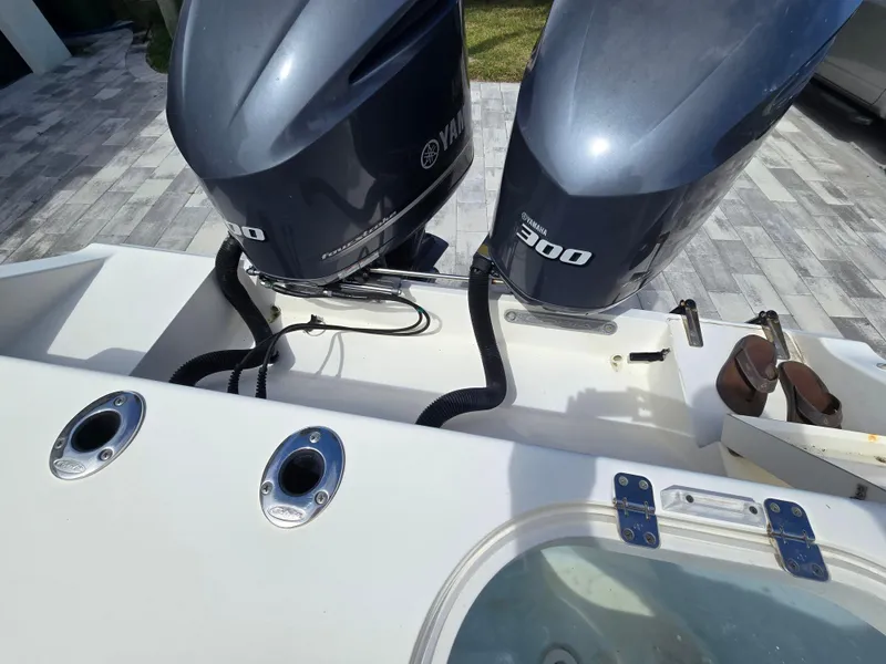 Slide: The Image of 2015 Cobia 296 Center Console with dual Yamaha 300 engines, docked on a sunny day. - 35