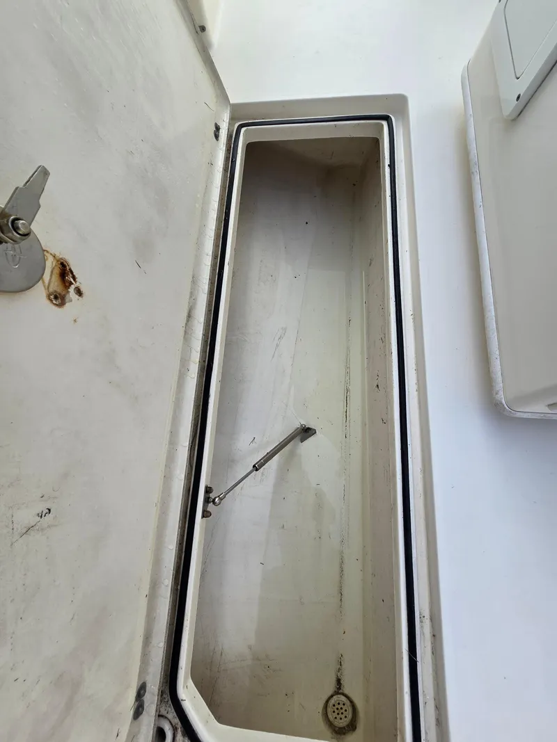 Slide: The Image of Open storage compartment on a 2015 Cobia 296 Center Console boat. - 36