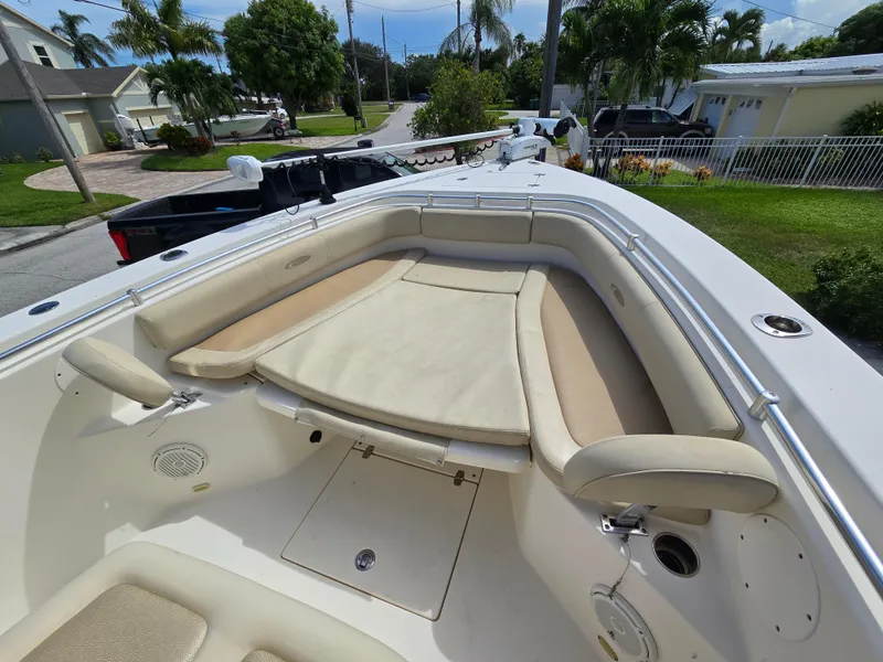 Slide: The Image of 2015 Cobia 296 Center Console boat with beige seating in a residential area. - 43