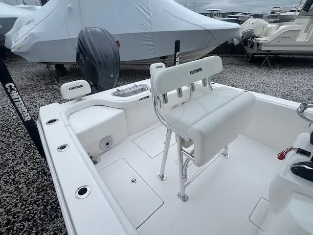 Slide: The Image of 2024 Contender 24 Sport boat interior with seating and motor, displayed outdoors. - 2