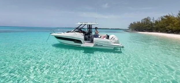Slide: The Image of 2024 Jeanneau Leader 9.0WA S2 boat on clear turquoise water near a sandy beach. - 1
