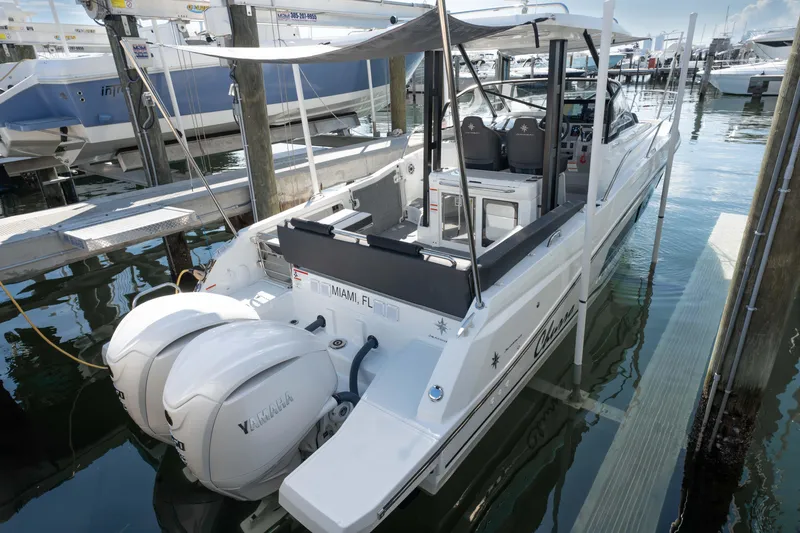 Slide: The Image of 2024 Jeanneau Leader 9.0WA S2 boat docked with twin outboard engines. - 10
