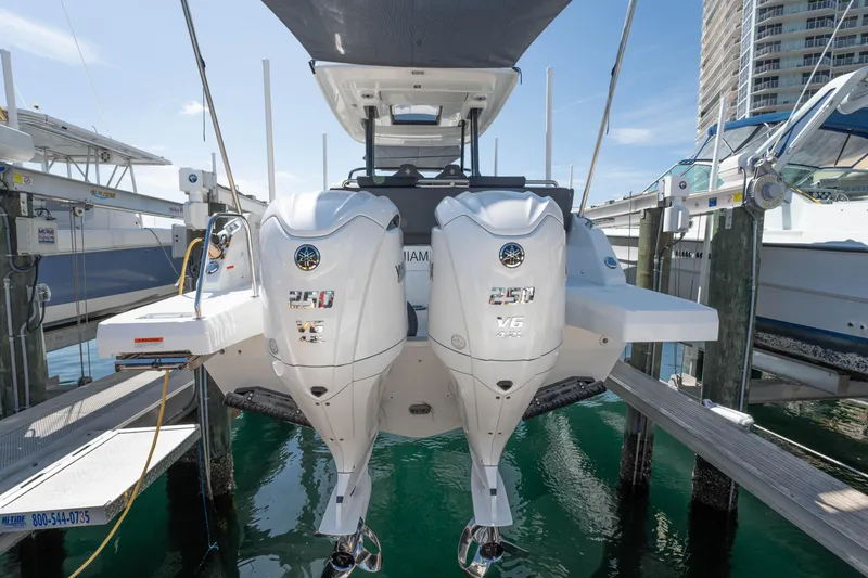Slide: The Image of 2024 Jeanneau Leader 9.0WA S2 with dual outboard engines docked at marina. - 11