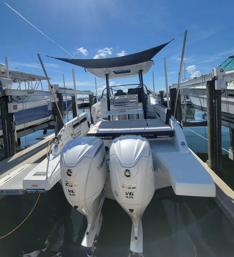 Slide: The Image of 2024 Jeanneau Leader 9.0WA S2 boat with twin Yamaha engines docked under blue sky. - 13